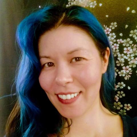 Woman smiling directly at camera with long blue hair