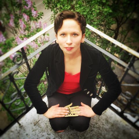 Person in red top and black blazer looking up