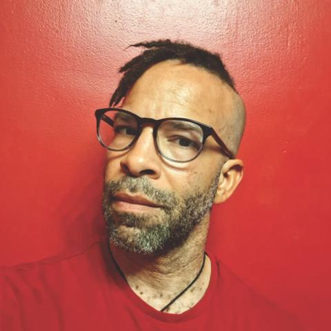 Douglas Kearney in glasses wearing a red shirt.