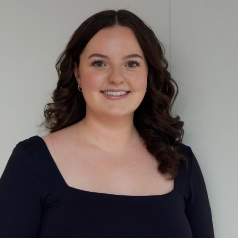 Woman smiling directly at camera with long wavy black hair