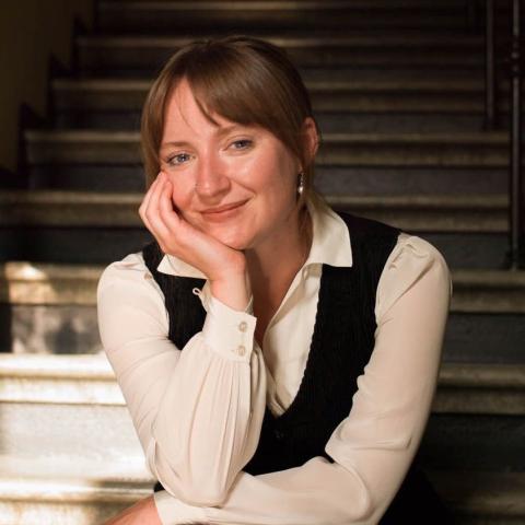 Woman in a relaxed pose smiling directly at the camera