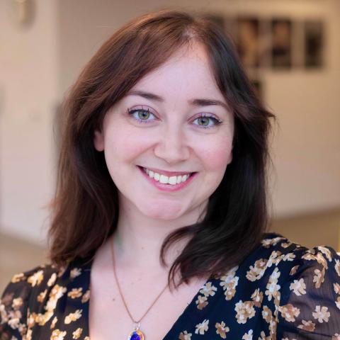 Woman with dark brown shoulder length hair smiling directly at the camera
