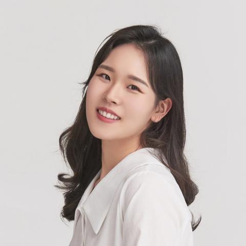 Woman with long black hair smiling at camera with head tilted back