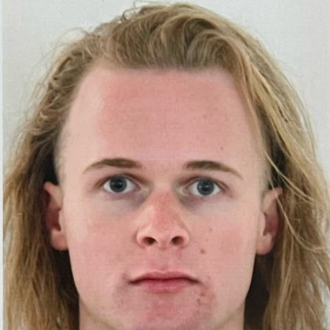 Man with shoulder length hair staring directly at the camera