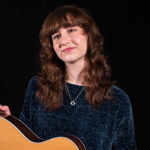 Woman holding guitar on lap