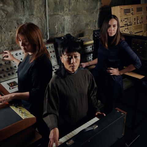 3 people surrounded by instruments in a circle