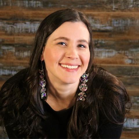 Katherena Vermette leans forward and smiles at the camera 