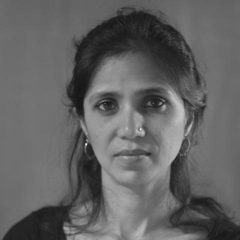 Woman in black and white photo with shoulder length hair staring directly at camera