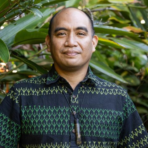 Indigenous Hawaiian men wearing green patterned shirt standing in nature