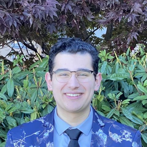 Man smiling at camera in colourful patterned jacket