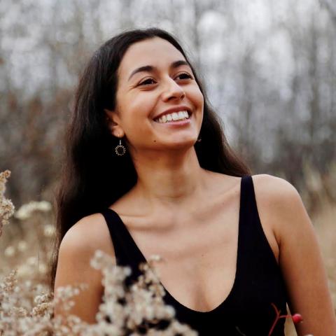 Smiling woman standing in a natural setting looking off camera