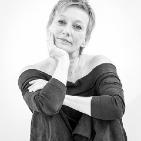 A black and white photo of Marie-Josée Chartier, sits with her head in her hand