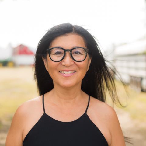 Musician Megumi Masaki stands outside with a blurred background