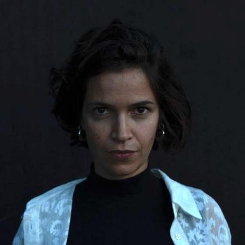 Dark filtered photo of woman staring directly at camera