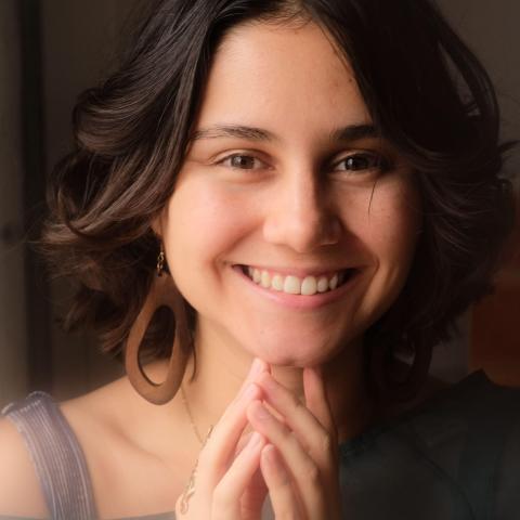 Person with long brown hair smiling at the camera