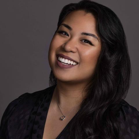 Woman in v neck blouse smiling broadly at camera