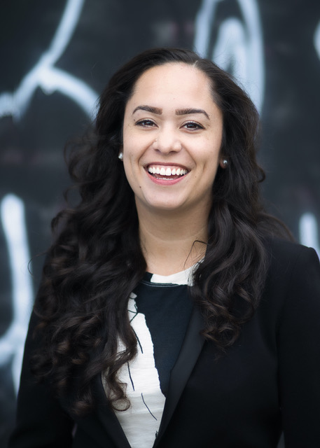 Woman with long black hair smiling broadly at camera